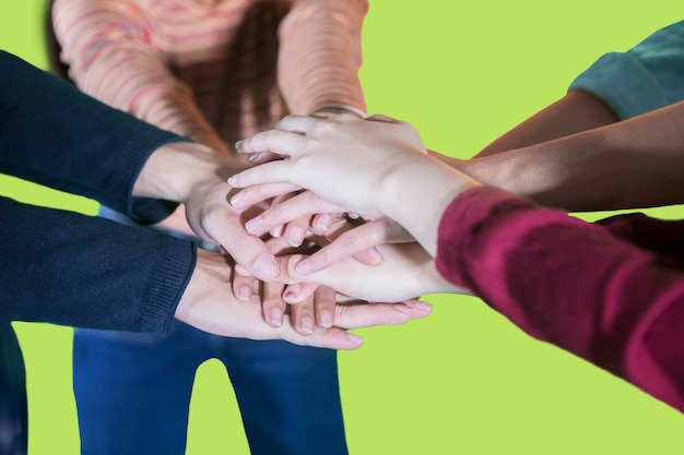 Foto sección media de amigos apilados contra un fondo verde