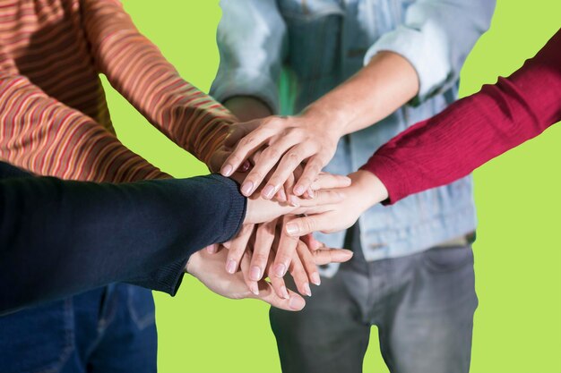 Sección media de amigos apilados contra un fondo verde