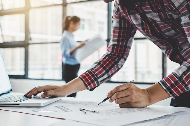 Sección media de arquitectos trabajando en el plano sobre la mesa