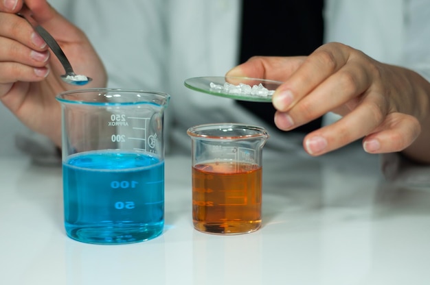 Foto sección media de un científico probando un experimento químico en el laboratorio