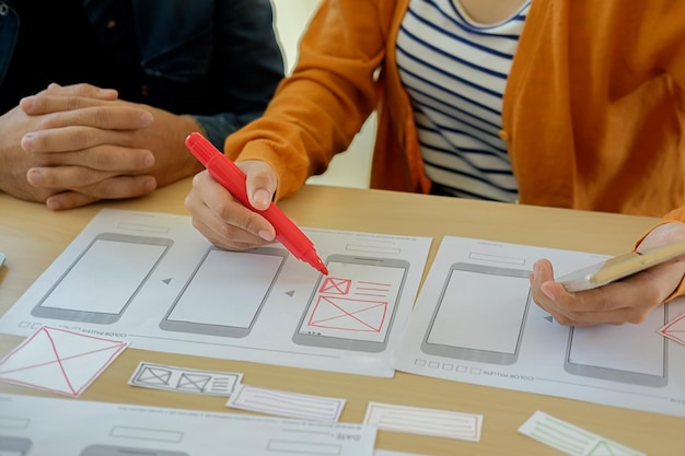 Sección media de colegas dibujando en papel en la oficina