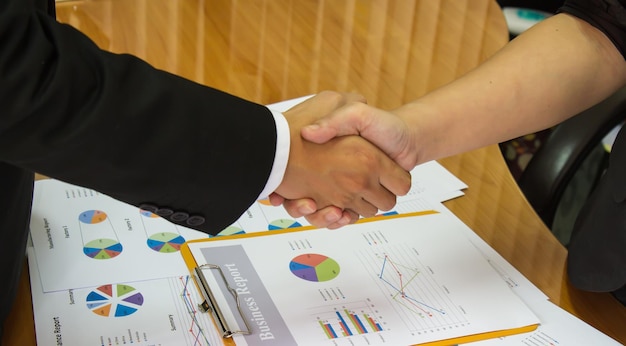 Foto sección media de colegas estrechando la mano en la oficina