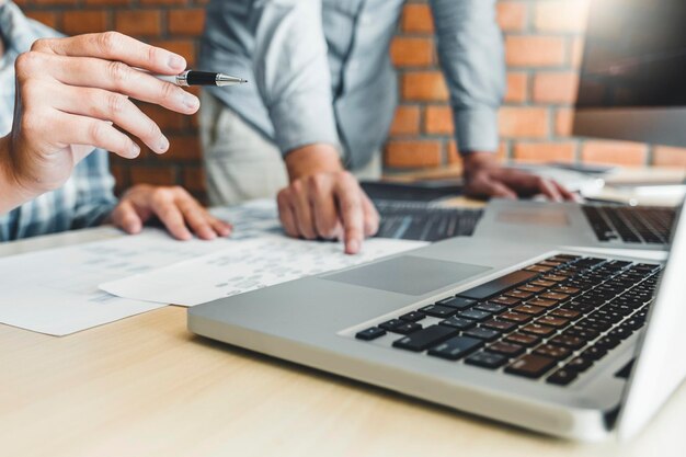 Sección media de compañeros de trabajo discutiendo en la computadora en la oficina