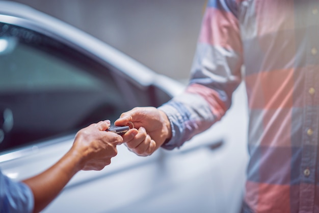 Foto sección media del concesionario de automóviles dando llaves a un cliente