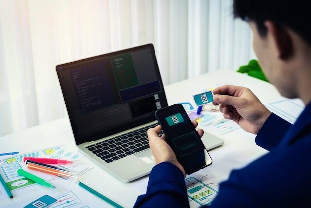 Sección media de desarrollador de software usando teléfono móvil en la mesa