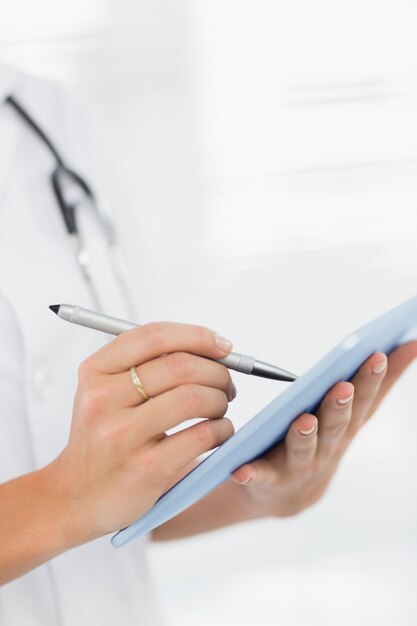 Foto sección media de una doctora usando tableta digital