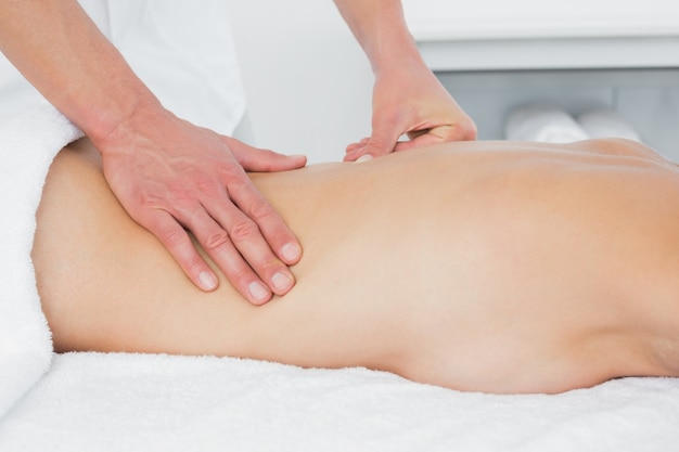 Sección media de un fisioterapeuta dando masajes a la mujer