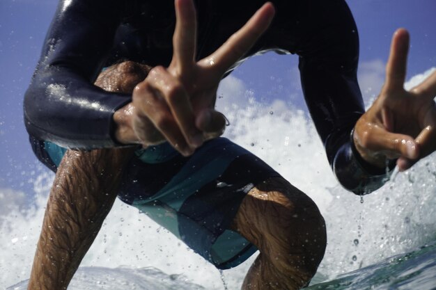 Foto sección media de un hombre con los brazos levantados en el mar