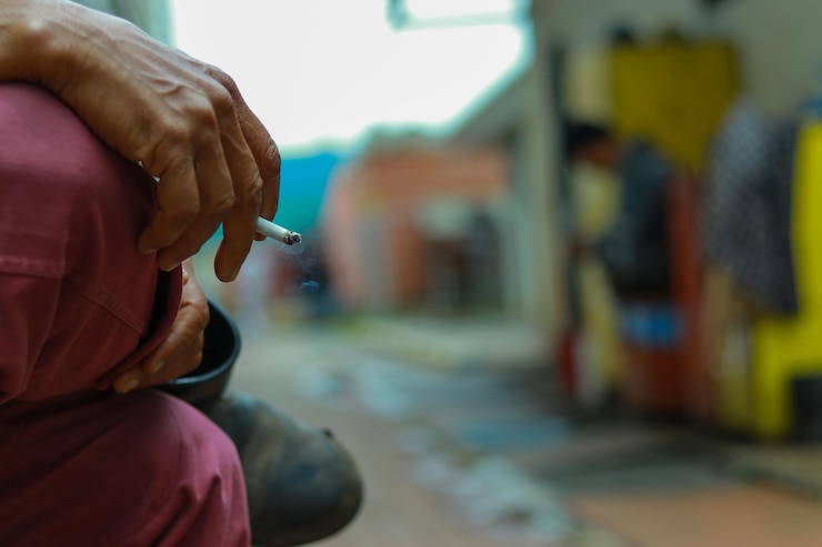 Foto sección media de un hombre con un cigarrillo en la ciudad