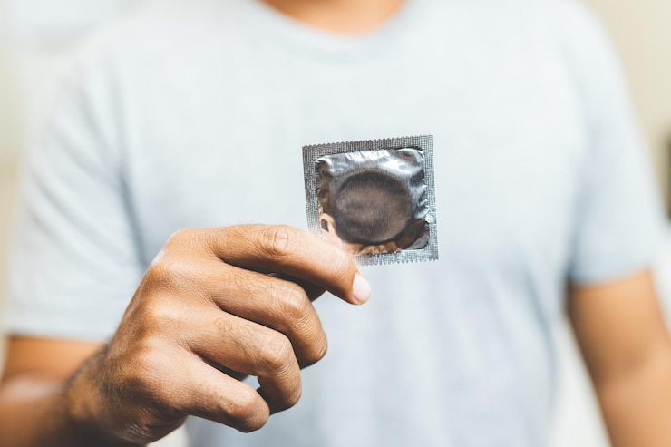 Foto sección media de un hombre con un condón