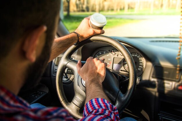 Sección media de un hombre conduciendo un coche en la carretera