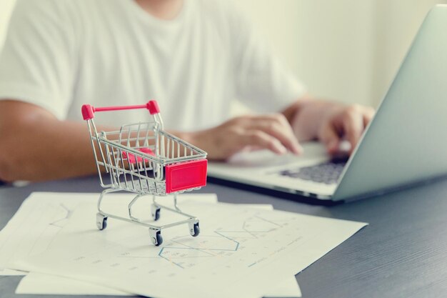 Sección media de un hombre haciendo compras en línea a través de una computadora portátil