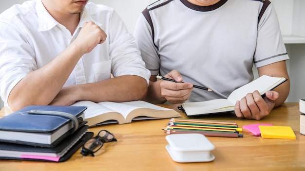 Sección media de un hombre leyendo un libro en la mesa