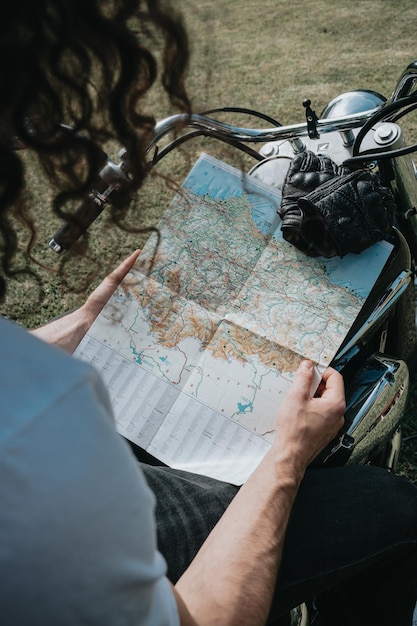 Foto sección media de un hombre leyendo un mapa en una motocicleta