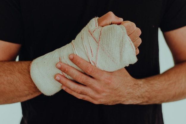 Sección media de un hombre con la mano envuelta en vendaje