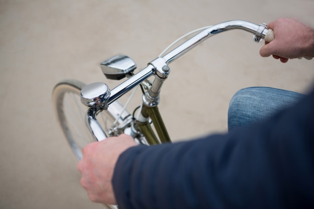 Sección media del hombre montando bicicleta en la playa