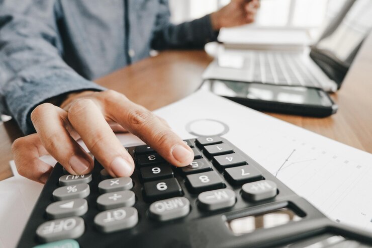 Foto sección media de un hombre de negocios calculando en un escritorio en la oficina