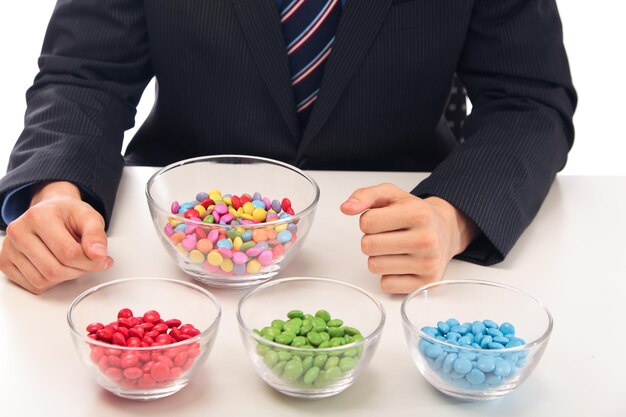 Foto sección media de un hombre de negocios con dulces en un cuenco en la mesa