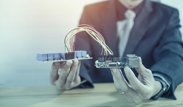 Sección media de un hombre de negocios sosteniendo una parte de la computadora sobre la mesa