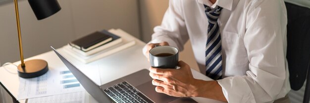 Foto sección media de un hombre de negocios sosteniendo una taza de café
