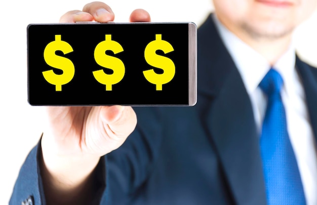 Foto sección media de un hombre de negocios sosteniendo un teléfono inteligente con signos de dólar contra un fondo blanco