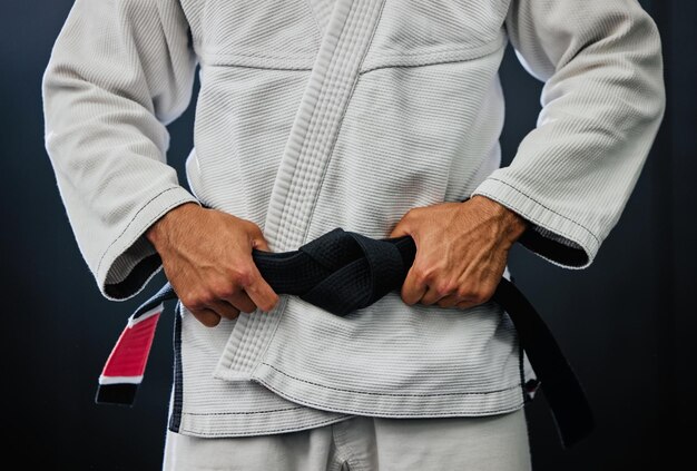 Foto sección media de un hombre de pie contra un fondo negro