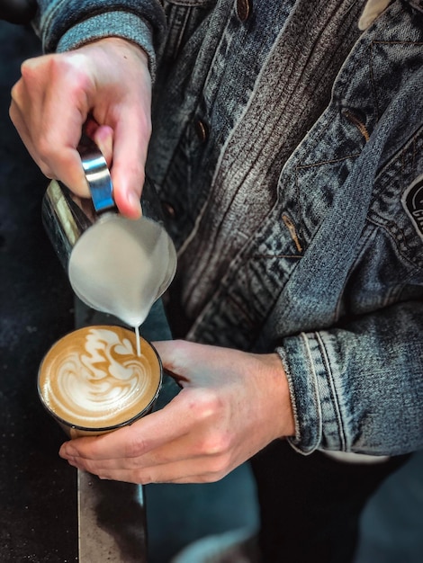 Foto sección media de un hombre preparando café en una cafetería