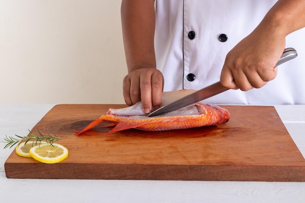 Foto sección media de un hombre preparando comida en una tabla de cortar