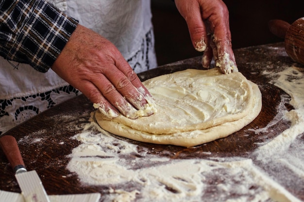 Sección media de un hombre preparando masa en la cocina