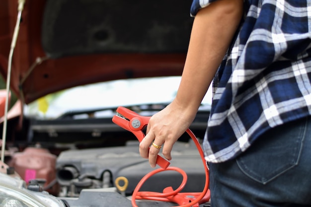 Sección media del hombre que sostiene la cámara mientras está de pie junto al coche