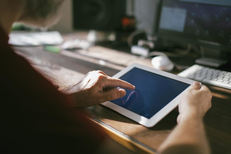 Foto sección media de un hombre que usa una tableta digital en la mesa