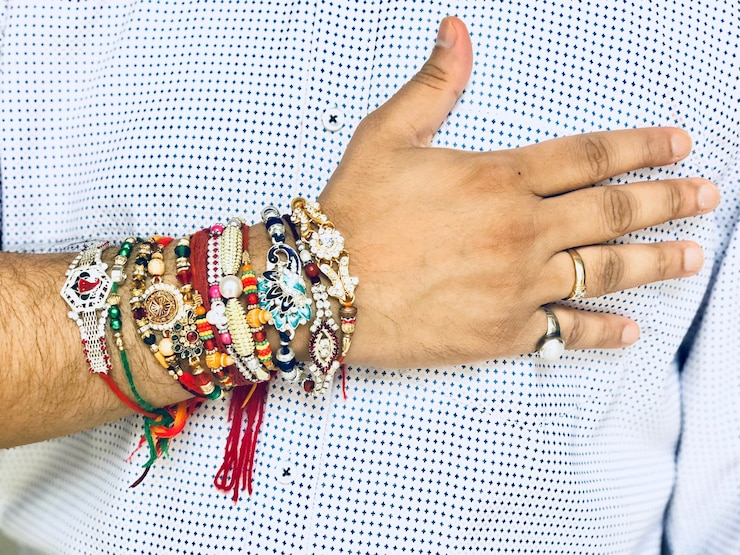 Foto sección media de un hombre con rakhis en la mano