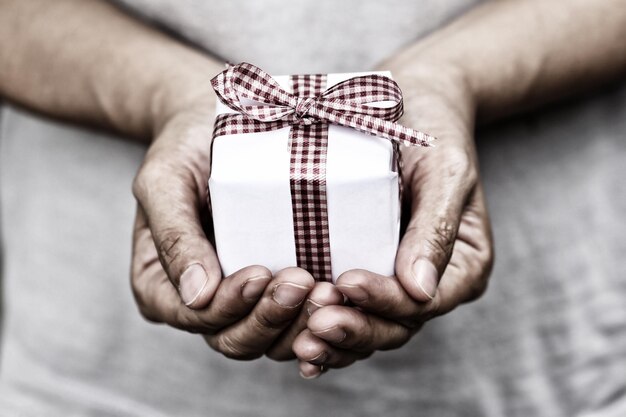 Foto sección media de un hombre sosteniendo una caja de regalos