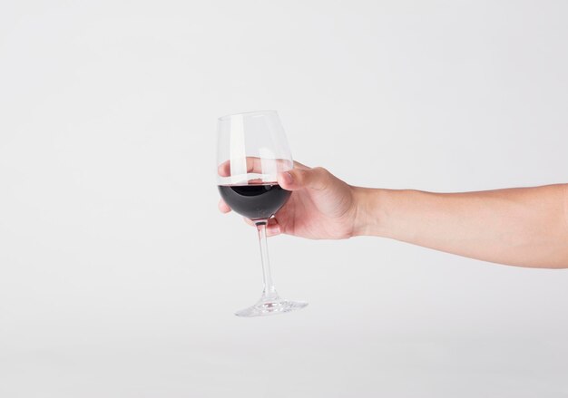 Foto sección media de un hombre sosteniendo una copa de vino contra un fondo blanco