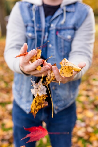 Foto sección media de un hombre sosteniendo hojas de otoño