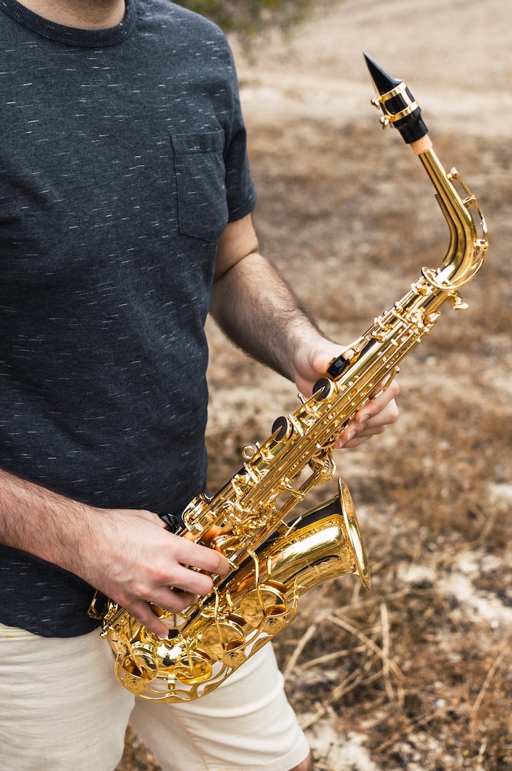 Foto sección media de un hombre sosteniendo un instrumento musical mientras está de pie en tierra
