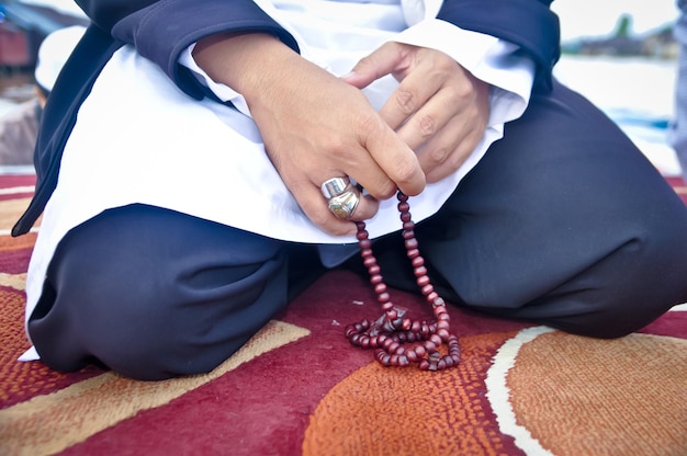 Foto sección media de un hombre sosteniendo joyas de perlas
