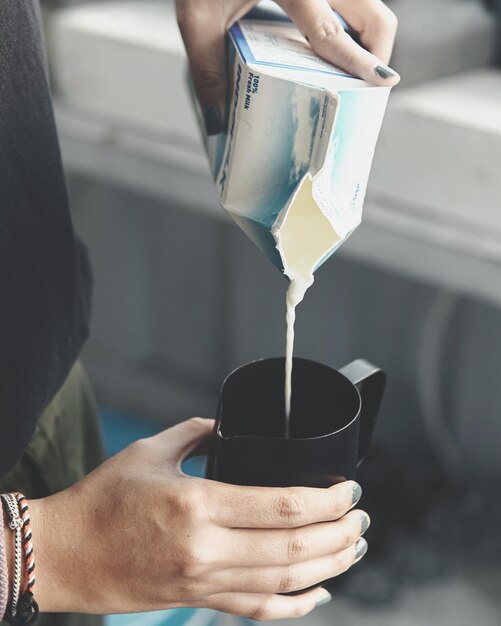 Foto sección media de un hombre sosteniendo leche fresca y jarro de leche