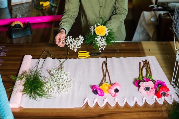 Foto sección media de un hombre sosteniendo un ramo de flores en la mesa