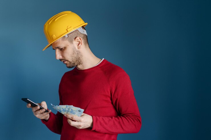 Foto sección media de un hombre sosteniendo un teléfono móvil contra un fondo azul