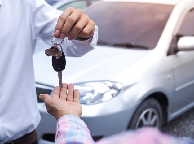 Sección media de un hombre con un teléfono inteligente en el coche