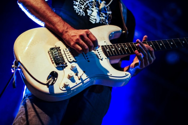 Sección media de un hombre tocando la guitarra en un concierto