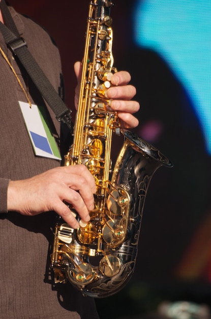 Sección media de un hombre tocando el saxofón en un concierto de música