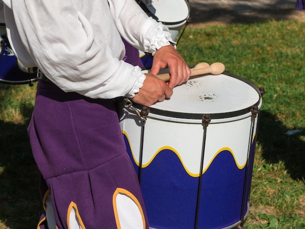 Sección media de un hombre tocando el tambor mientras está de pie al aire libre