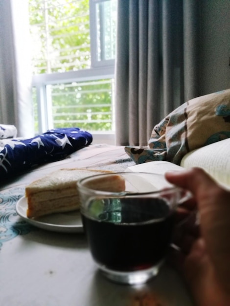 Foto sección media de un hombre tomando el desayuno en la mesa en casa