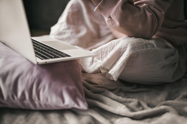 Foto sección media de un hombre usando una computadora portátil en la cama en casa