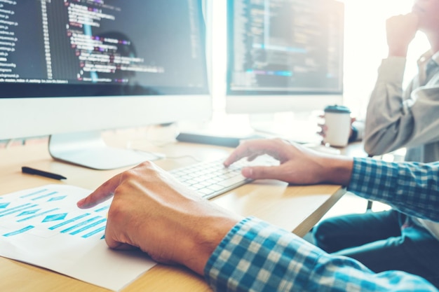 Sección media de un hombre usando una computadora portátil en la mesa