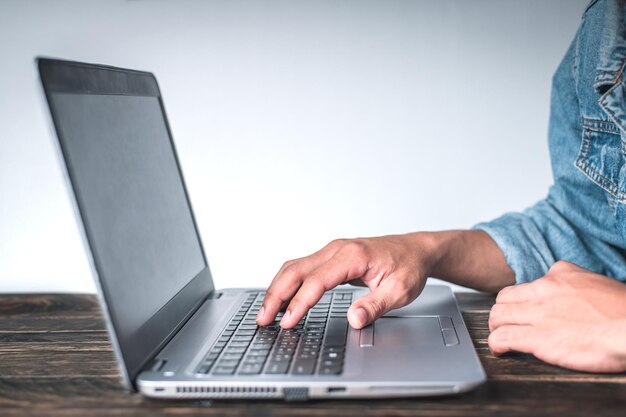 Sección media de un hombre usando una computadora portátil en la mesa