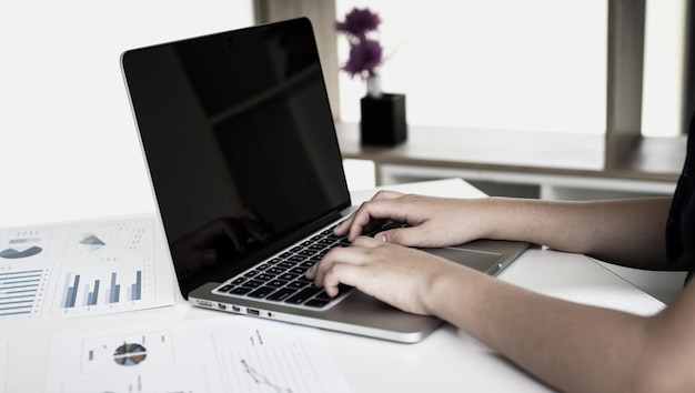 Sección media de un hombre usando una computadora portátil en la mesa