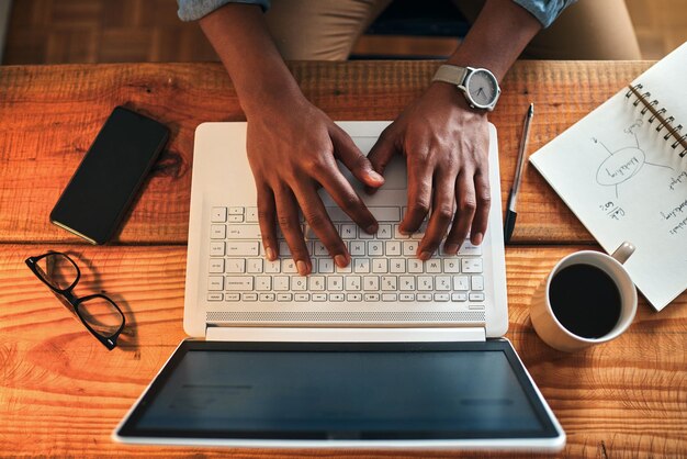 Foto sección media de un hombre usando una computadora portátil en la mesa